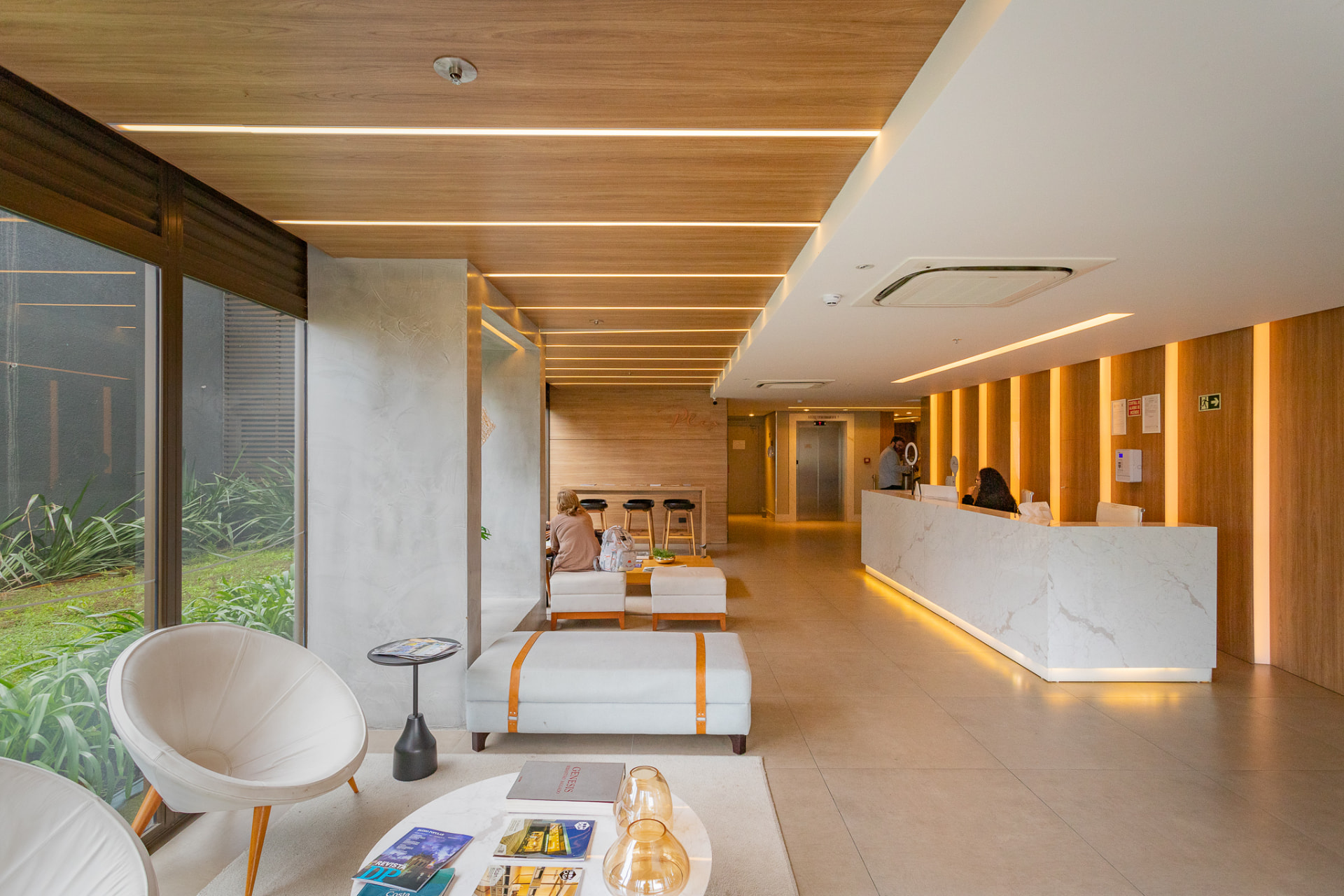 Hall de entrada do Plex, no Parque Una, com recepção em mármore e pé-direito duplo